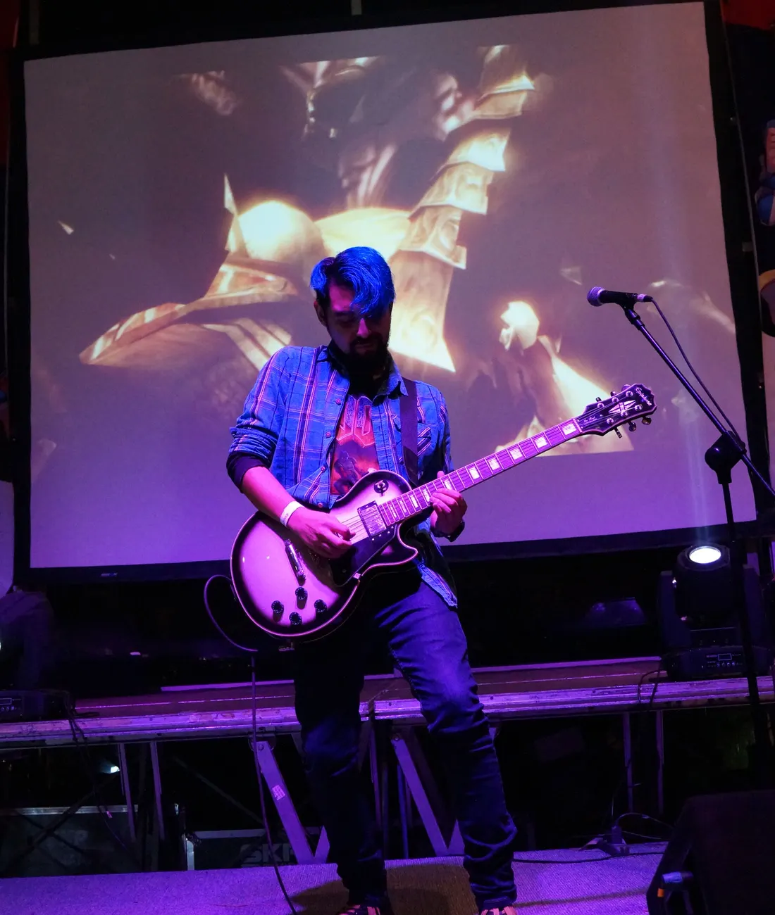 Kris Escobar en el escenario con una Les Paul, pelo azul y luz rosada